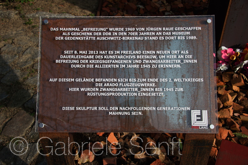 25.03.2015 auf dem Gelände des Jugendkulturzetrums Freiland befindet sich diese Plastik des Berliner Bildhauers Jürgen Raue.. Es ist eine kleine Anfertigung des für Greiz geschaffenen Mahnmals, die dort 1971 am Eingang des Greiner Parks stand, um an die mindestens 12 Zwangsarbeiterlager in der Stadt und Umgebung zu erinnern. 2006 beschloss der Greizer Stadtrat, die Plastik in einen nicht mehr genutzten Teil eines Friedhofes zu verbannen. Eine zweite Ausfertigung wurde von der DDR der Gedenkstätte Auschwitz Birkenau geschenkt. 1989 wurde diese in ein Depot eingelagert.Dem Junstarvhib Beeskow und Mitarbeitern der Gesellschaft zum Schutz von Bürgerrecht und Menschenwürde ist es zu verdanken, dass diese Plastik nun einen würdigen Platz auf dem Potsdamer Freiland Gelände zu sehnen ist. Texttafel neben dem Mahnmal 2015-03-25 um 15-32-20.jpg